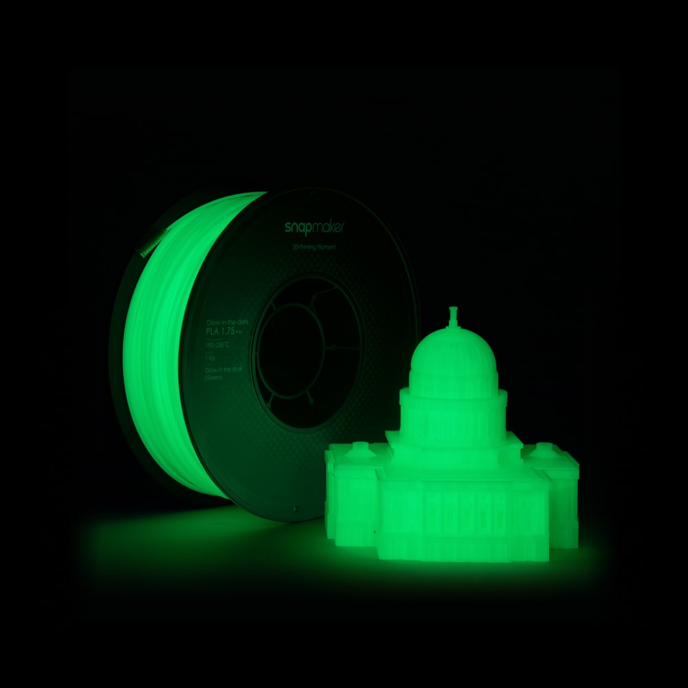 Snapmaker Glow-in-the-dark Green PLA filament spool and a glowing 3D printed castle model.